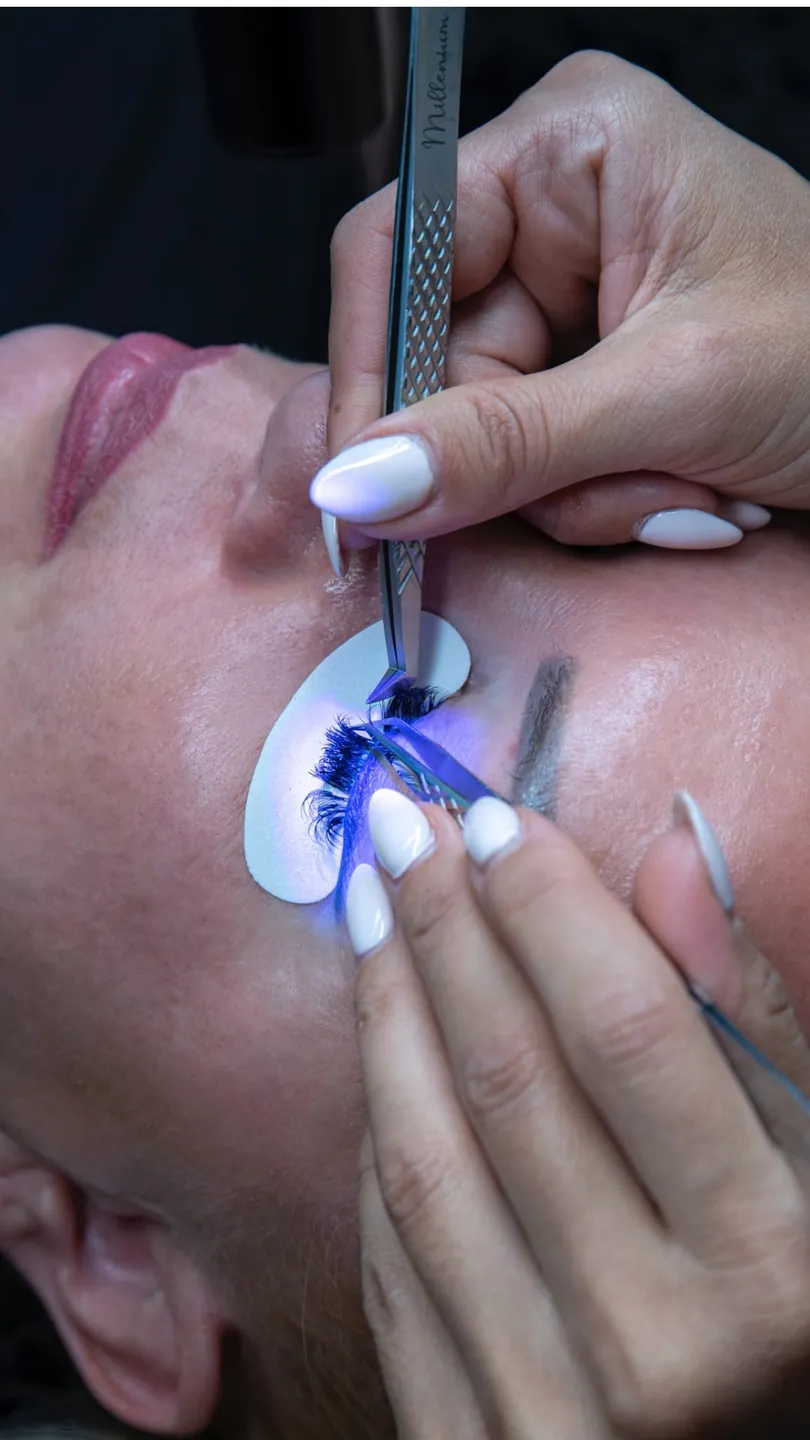 Wimpernverlängerung mit UV-Technik – einzelne Wimpern werden mit der Pinzette unter UV-Licht angesetzt
